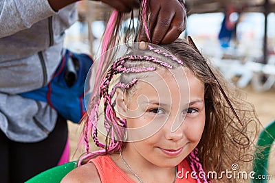 Beautiful girl making trendy braids dreadlocks. Afro American female hand at work Stock Photo