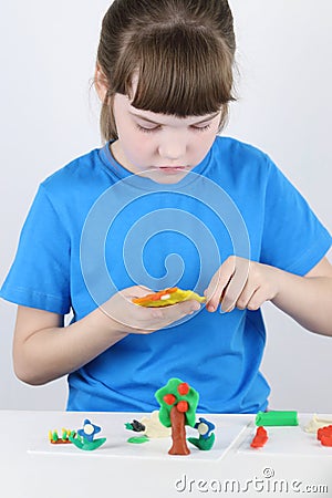 Beautiful girl molds toys from plasticine Stock Photo