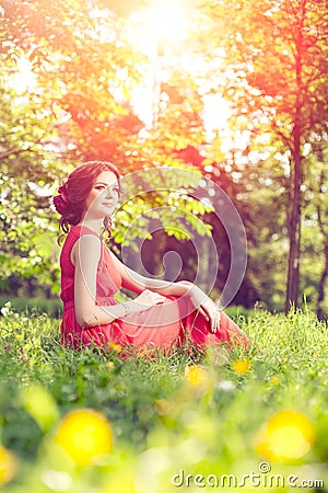 Beautiful girl on the nature in the park. Against the background Stock Photo