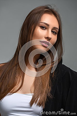 Girl in white with a black jacket on a light background Stock Photo