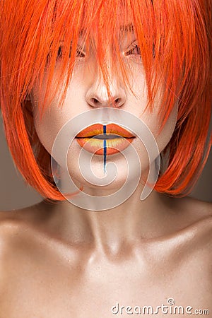 Beautiful girl in an orange wig cosplay style with bright creative lips. Art beauty image. Stock Photo