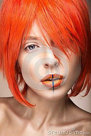 Beautiful girl in an orange wig cosplay style with bright creative lips. Art beauty image. Stock Photo