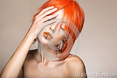 Beautiful girl in an orange wig cosplay style with bright creative lips. Art beauty image. Stock Photo