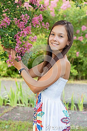 Beautiful girl in the park under the lilac tree. Stock Photo