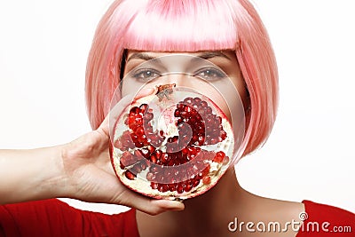 Girl with pomegranate. Pink hair Stock Photo