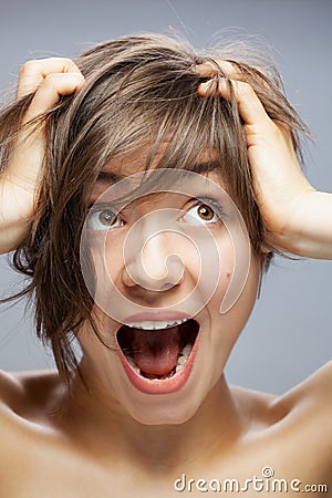 Beautiful girl portrait screaming, surprised expression. hands on head Stock Photo