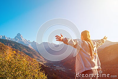 Beautiful girl with raised arms to the mountains of Svaneti, mountain Ushba, relax while traveling Stock Photo