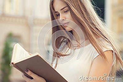 Beautiful girl reading outdoors Stock Photo