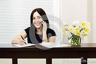 Beautiful girl at the reception desk answering the call in dental office Stock Photo