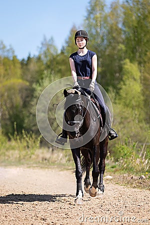 Beautiful girl riding a horse on manege Stock Photo