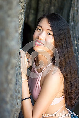 Beautiful girl in the shade of beach cave Stock Photo