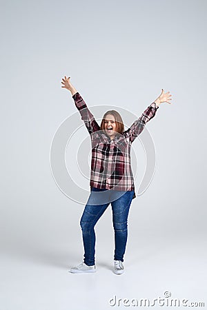 Beautiful girl in shirt and jeans holding arms outstretched Stock Photo