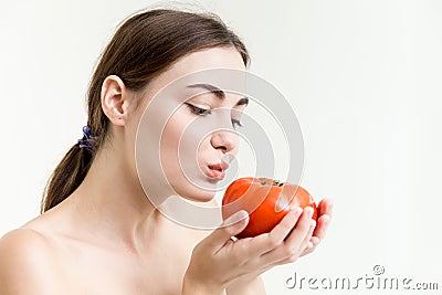 Beautiful girl is showing and kiss a big red tomato healthy high nutrition vegetable Stock Photo