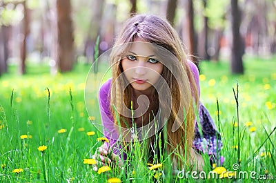 Beautiful girl sit down on the grass with flowers Stock Photo