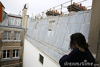 Beautiful girl siting on the Paris roof. Stock Photo