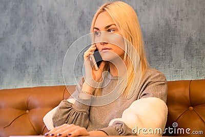 Beautiful girl sitting in the cafe and talking on smart phone Stock Photo