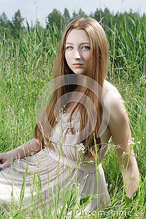 Beautiful girl sitting on grass Stock Photo