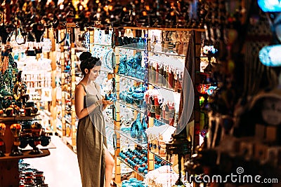 Beautiful girl in a souvenir shop in Turkey. Girl chooses a souvenir Oriental shop. Turkish Souvenirs. Oriental bazaar. Stock Photo