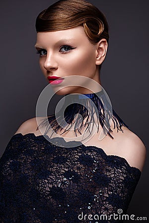 Beautiful girl in the style Gatsby with a collar of feathers and lace blue dress. Model with the hairstyle from the 20s of the Stock Photo