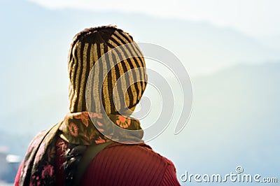 Beautiful girl in summer vacation in woolen hat in sunny day. Woman traveler looking at amazing mountain, Back view. Wanderlust Stock Photo