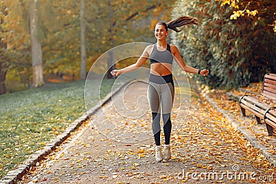 Sports girl in a black top training in a autumn park Stock Photo