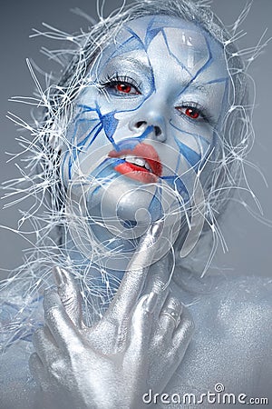 Beautiful girl in an unusual winter look with red lips. Creative make- up. Art look. Stock Photo