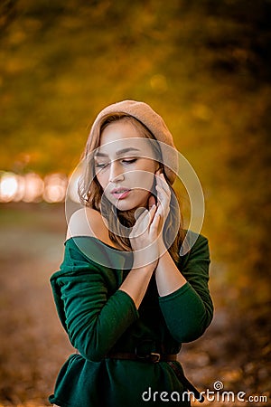 Beautiful girl walking outdoors in autumn. Smiling girl collects yellow leaves in autumn. Young woman enjoying autumn weather Stock Photo