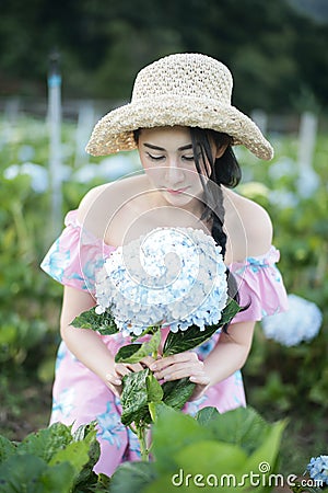 Beautiful girl with a field of hydrangea flowers Stock Photo