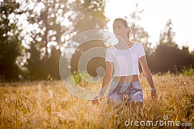 A beautiful girl in a wheatfield on sunset Stock Photo