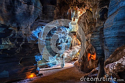 Beautiful girl in white dress walking in blue cave, Thailand Stock Photo