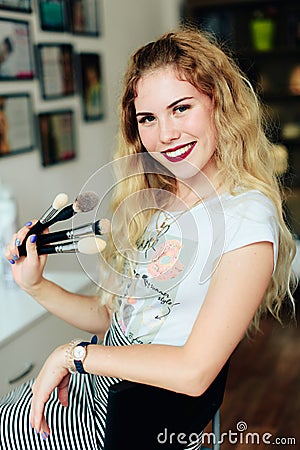 Beautiful girl with white hair with brushes in her hands, profession of make-up artist Stock Photo