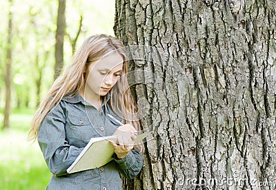 Beautiful girl writes on nature Stock Photo