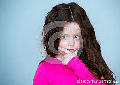 Beautiful girl 4-5 years old with long brown hair. The child is puzzled. In thought Stock Photo