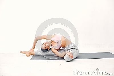 A beautiful girl is engaged in a yoga studio Stock Photo