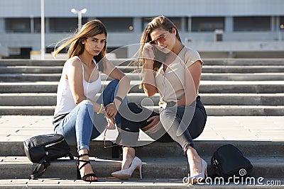 Beautiful girls in a city. Stylish ladies sitting on a stairs Stock Photo