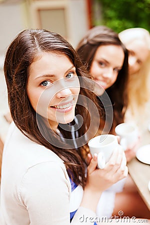 Beautiful girls drinking coffee in cafe Stock Photo