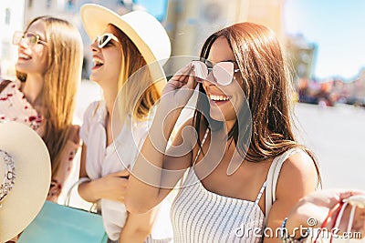 Beautiful girls in sunglasses with shopping bags in city Stock Photo