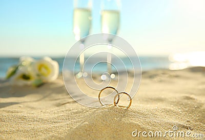Beautiful gold wedding rings on sandy beach Stock Photo
