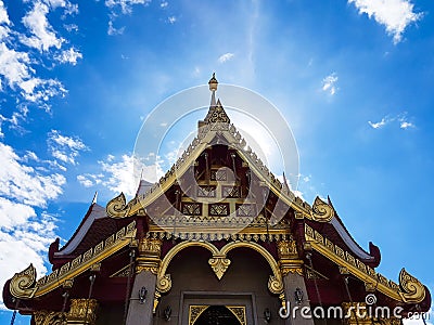 Beautiful golden chapel of temple with a backdrop of blue sky Stock Photo