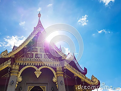 Beautiful golden chapel of temple with a backdrop of blue sky Stock Photo