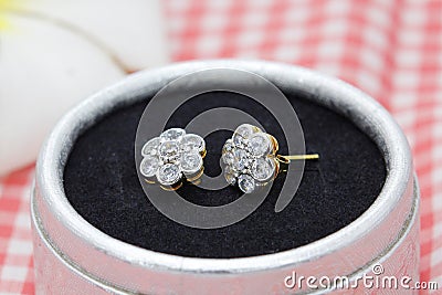 Beautiful golden earrings decorated with diamond in flower shape display in jewelry box Stock Photo