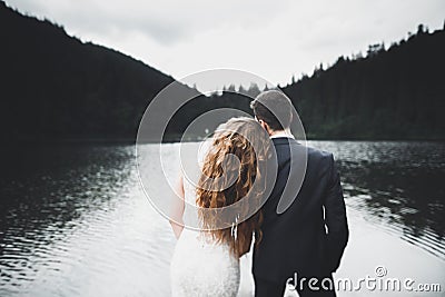 Beautiful gorgeous bride posing to groom and having fun, luxury ceremony at mountains with amazing view, space for text Stock Photo