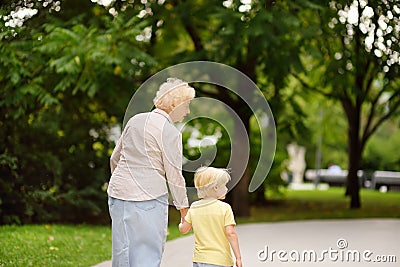 Beautiful granny and her little grandchild walking together in park Stock Photo