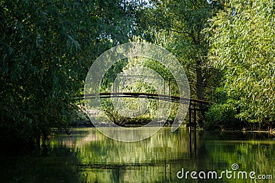 green landscape with river, bridge and reflextion of willow trees. Idyllic contryside scene Stock Photo