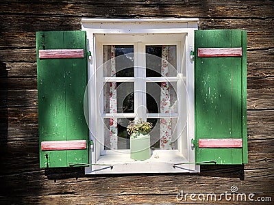 Beautiful green shutters and white window on typical and traditional austrian alpine wooden house - Salzkammergut Stock Photo