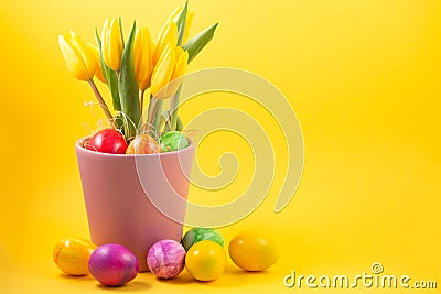 Beautiful group Easter eggs in the spring of easter day, red eggs, blue, purple and yellow in Tulip Pots on the Yellow background Stock Photo