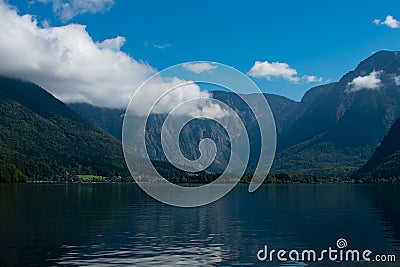 The beautiful HallstÃ¤tter See on a sunny autumn day with blue sky and clouds Stock Photo