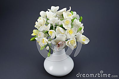 Hand made polymer clay flower bouquet in a white vase on a gray Stock Photo