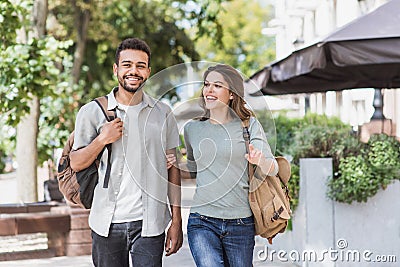 Beautiful happy couple summer portrait. Young joyful smiling woman and man walking in a city. Stock Photo