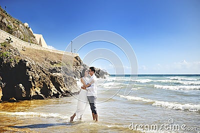 Beautiful happy couple together embracing on the beach, Sperlonga, Italy Stock Photo